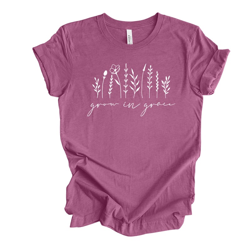 May include: A mauve t-shirt with a white graphic of stylized flowers and the text "grow in grace".