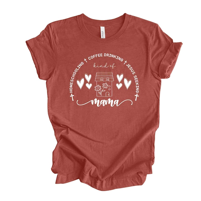 Puede incluir: Una camiseta roja con un dise&ntilde;o gr&aacute;fico blanco que dice "Homeschooling + Coffee Drinking + Jesus Seeking + kind of mama". El gr&aacute;fico tambi&eacute;n incluye una casa con una flor y corazones.