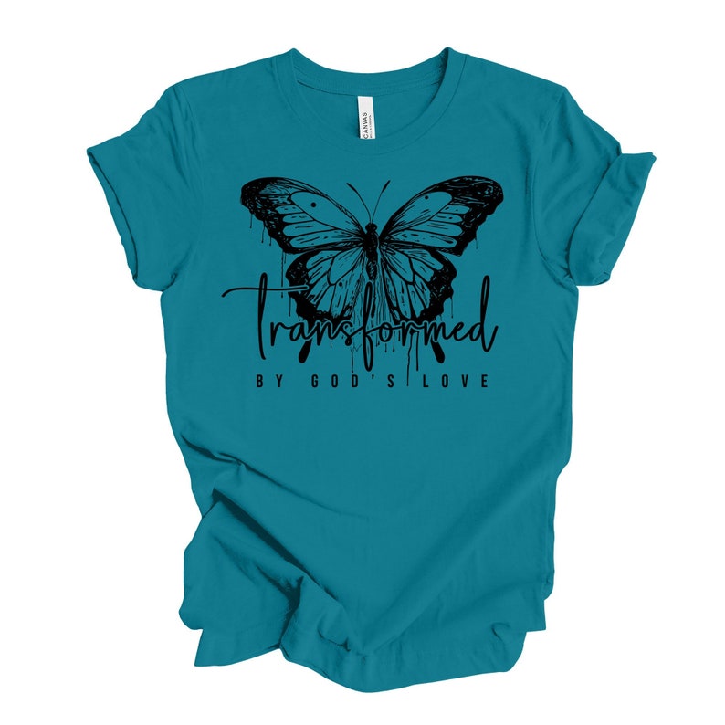 Peut inclure: T-shirt bleu turquoise avec un motif de papillon noir et le texte "transform&eacute; par l'amour de Dieu".