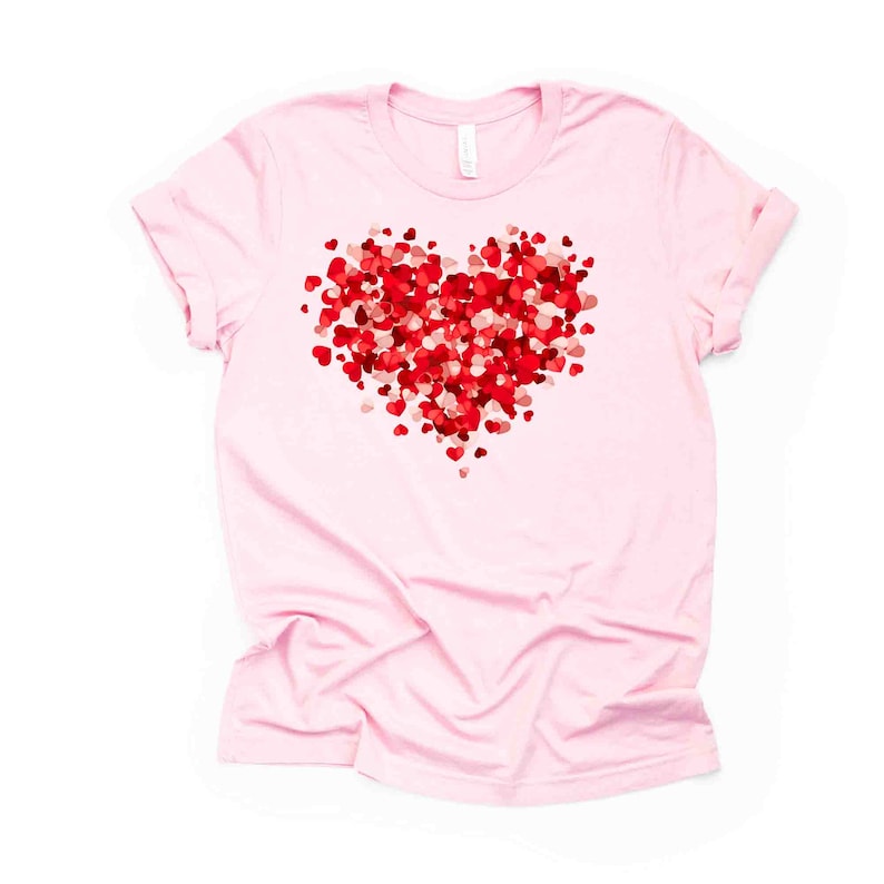 May include: A pink t-shirt with a red heart design made of many smaller hearts.