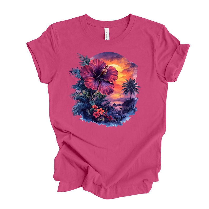 May include: A magenta t-shirt featuring a tropical design. The graphic includes a large purple hibiscus flower, palm trees, and a sunset scene. The shirt is made of a soft material and has a classic crew neck.