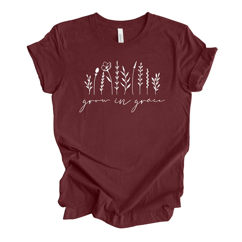 May include: A maroon t-shirt with a white graphic of stylized flowers and the text "grow in grace".