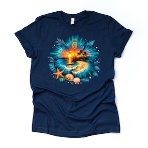 May include: Navy blue t-shirt featuring a vibrant tropical design. The graphic includes a sunset over a beach scene, a large turquoise flower, seashells, and a starfish. The design is detailed and colorful.