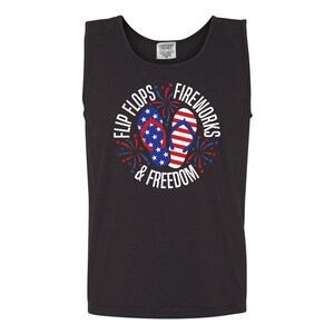 May include: Black tank top with a white graphic of red, white, and blue flip flops with stars and fireworks. The text reads "Flip Flops & Fireworks & Freedom".