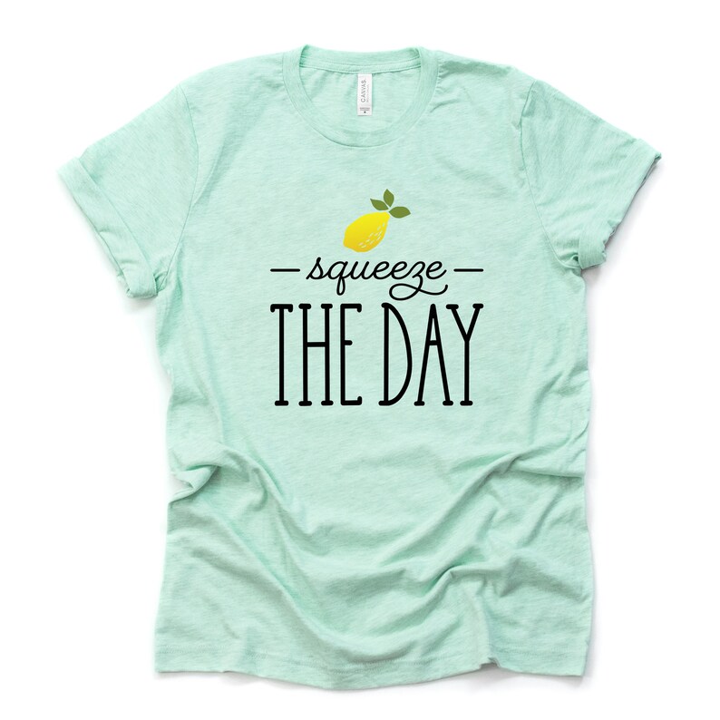 May include: A light green t-shirt with a yellow lemon and the text "squeeze the day" in black.