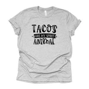 Puede incluir: Una camiseta gris con texto negro que dice "Tacos are my spirit animal".