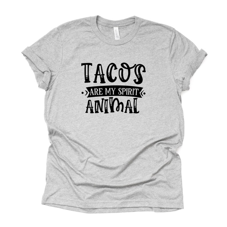 Puede incluir: Una camiseta gris con texto negro que dice "Tacos are my spirit animal".