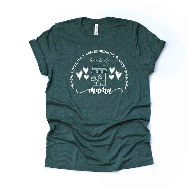 Puede incluir: Una camiseta verde oscuro con un dise&ntilde;o gr&aacute;fico blanco que dice "Homeschooling + Coffee Drinking + Jesus Seeking kind of mama" con una casa y corazones alrededor del texto.