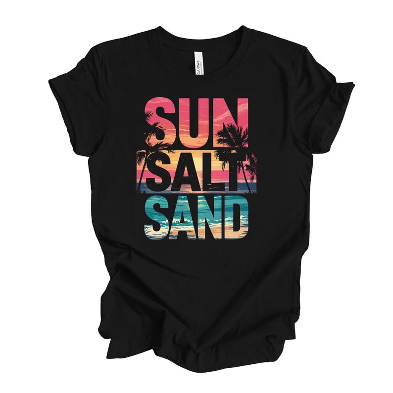 Op de afbeelding: Zwart t-shirt met de tekst "SUN SALT SAND" in een kleurrijk strandontwerp. De tekst is gelaagd met een zonsondergang en palmbomen, wat een tropische vakantiesfeer oproept.