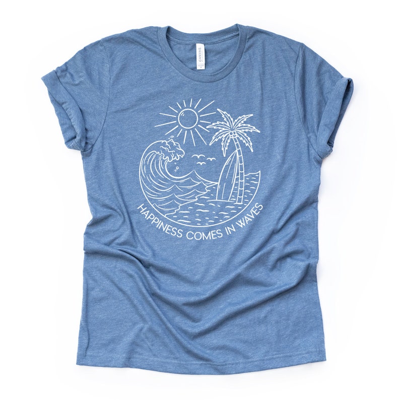 May include: A blue t-shirt with a white graphic design of a wave, palm tree, sun, and surfboard. The text "Happiness comes in waves" is written in a circle around the graphic.