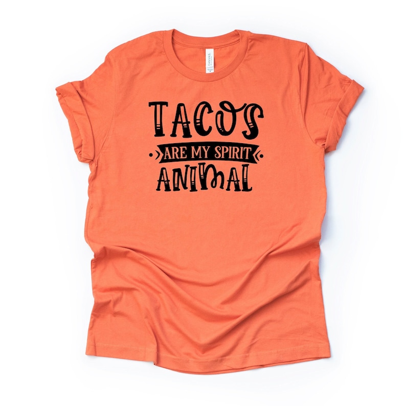 Puede incluir: Camiseta naranja con texto negro que dice "Tacos are my spirit animal".