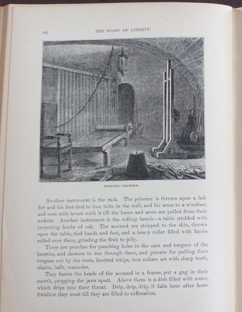 May include: A black and white illustration of a torture chamber, likely from a historical book. The image shows a rack, a rolling bench, and other instruments of torture. The scene is detailed, depicting the tools and the chamber's architectural features.