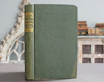 May include: A green hardcover book with gold lettering on the spine that reads "Letters to Young Ladies 1838". The book has an ornate design on the cover.