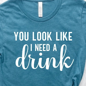 You Look Like Funny Quote Shirt: 'I Need a Drink' Design, Witty Party Tee | Cotton Blend, Eco Friendly, Unisex Sizes S-XXL image 1