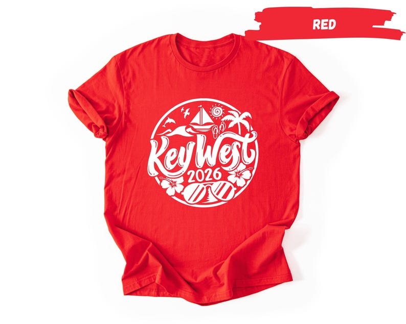 A red t-shirt with a white graphic design featuring a circular logo with the text "Key West" and "2026" printed on it.
