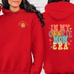 a woman wearing a red hoodie with a cookie on it