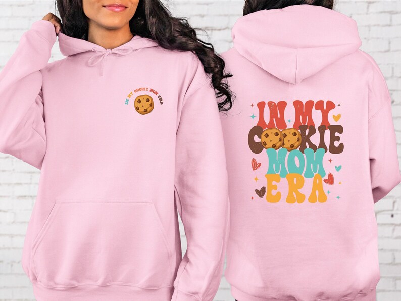 a woman wearing a pink hoodie with a cookie on it