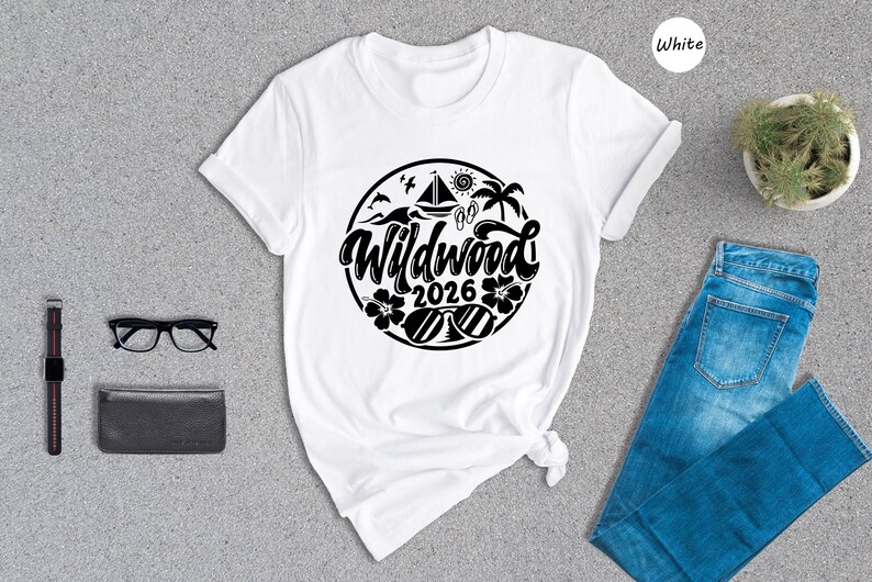 a white t-shirt with a graphic design, a pair of blue jeans, a pair of glasses, a wallet, and a potted plant, all laid out on a gray surface.