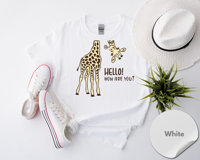 a white t-shirt with a giraffe graphic and the text "Hello! How Are You?" printed on it, along with a pair of white sneakers and a white hat.