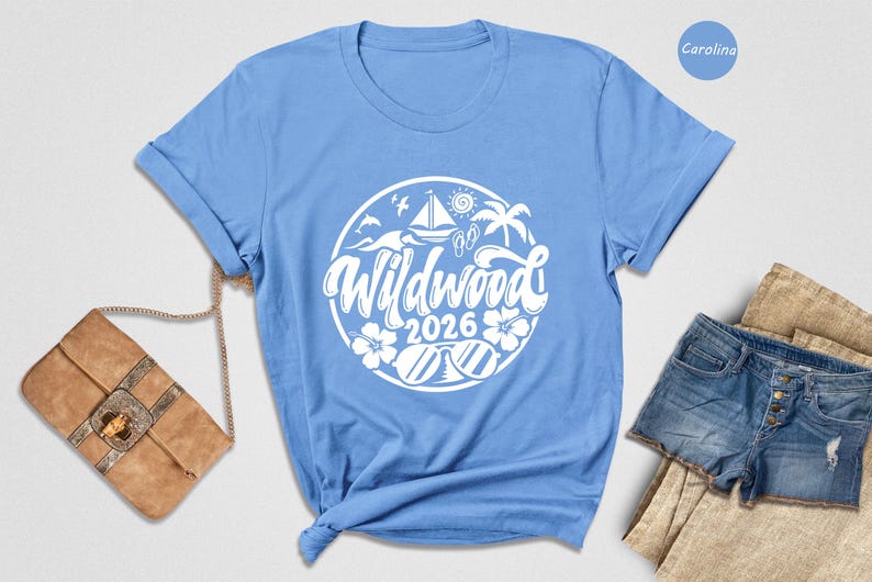 A blue t-shirt with a white graphic design, a brown purse, and a pair of denim shorts are arranged on a white background.