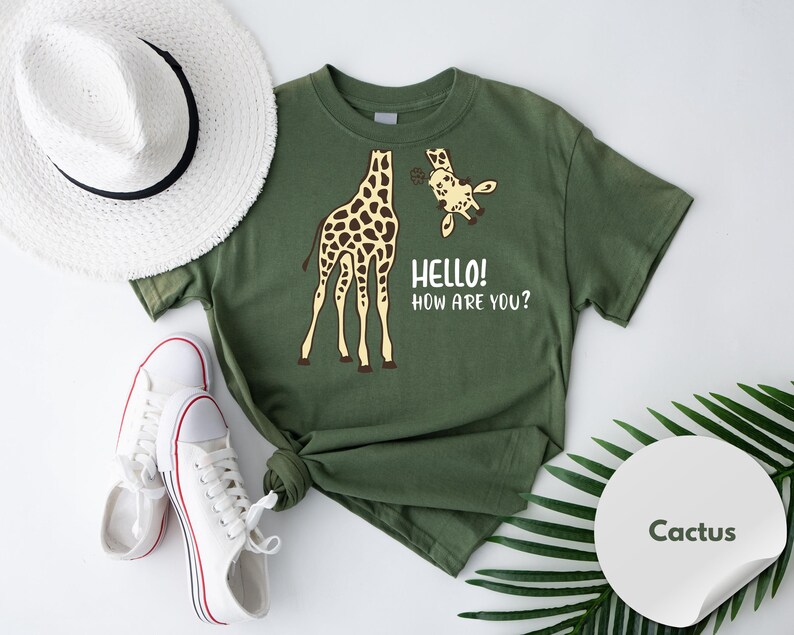 a green t-shirt with a giraffe and a smaller giraffe, along with a hat, sneakers, and a palm leaf.
