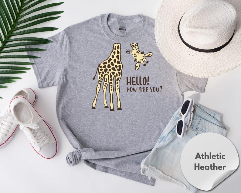 a gray t-shirt with a giraffe graphic and the text "Hello! How are you?" printed on it, along with a straw hat, sunglasses, and athletic shorts.