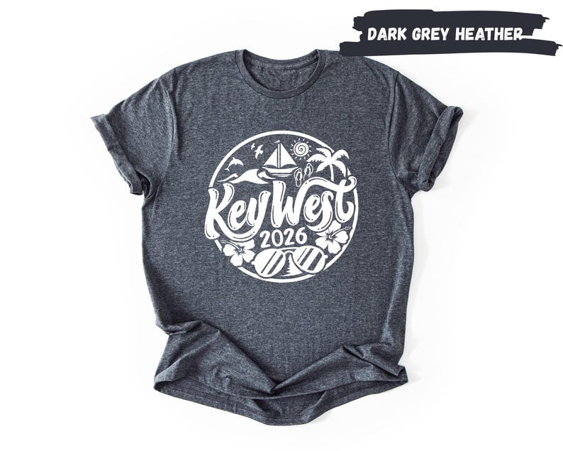 A gray t-shirt with a graphic design featuring a circular logo with the text "Key West" and the year "2026" printed on it.