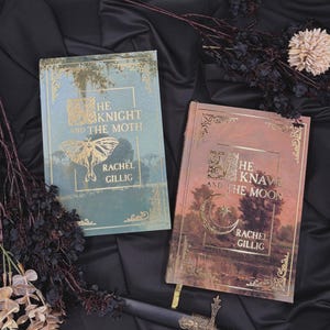 May include: Two hardcover books with gold foil lettering and decorative borders. The left book is sage green with a moth illustration and the text "The Knight and the Moth" by Rachel Gillig. The right book is copper with a moon and star design.