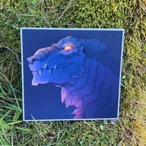 Può includere: Un primo piano di una testa di drago blu e viola con un occhio arancione incandescente. Il drago è rivolto a destra e ha denti affilati. Lo sfondo è blu scuro.