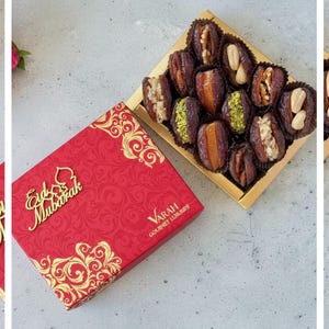 May include: A red gift box with gold floral designs and the words "Eid Mubarak" in gold script. A gold tray holds dates filled with nuts and pistachios. The box is labeled "Varah Gourmet Luxuries".