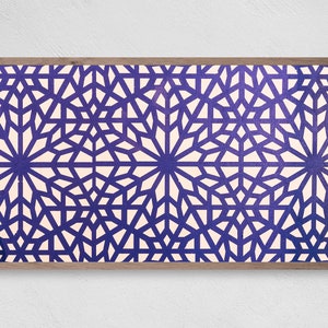 Op de afbeelding: Een ingelijst drukwerk met een geometrisch patroon van witte sterren op een dieppaarse achtergrond.
