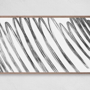 May include: A black and white abstract art print with a wood frame. The print features a series of diagonal lines that create a dynamic and modern look.