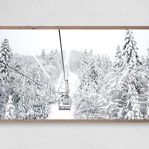 Könnte beinhalten: Ein Schwarzweißfoto eines Skilifts, der einen schneebedeckten Berg hinauf fährt. Die Bäume sind mit Schnee bedeckt und der Himmel ist bewölkt.