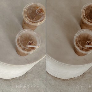 May include: Two iced coffee drinks in clear plastic cups with lids and straws on a white marble surface.