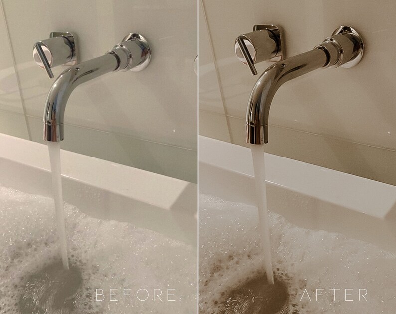May include: A chrome bathroom faucet with a single handle is mounted to a white wall. Water is flowing from the faucet into a white bathtub filled with bubbles.