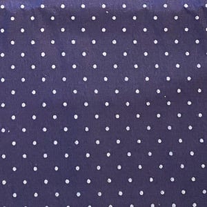 May include: A dark navy blue fabric featuring a repeating pattern of small, evenly spaced white polka dots arranged in a grid-like formation across the entire surface of the material, creating a consistent and uniform visual texture throughout.