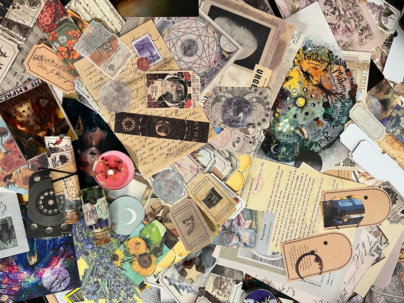 Puede incluir: Una colecci&oacute;n de ef&iacute;meras de estilo vintage, que incluye recortes de papel, pegatinas y elementos decorativos. El surtido presenta temas celestiales y bot&aacute;nicos, con ilustraciones de lunas, soles, flores y texto manuscrito.