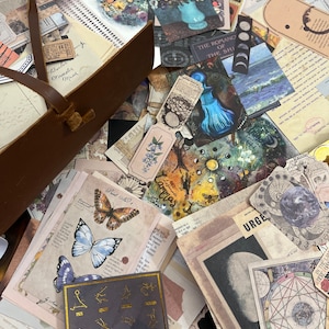 Puede incluir: Una colecci&oacute;n de ef&iacute;meras de estilo vintage, que incluye ilustraciones bot&aacute;nicas, estampados de mariposas y cartas celestes. El surtido presenta varias texturas, colores y tama&ntilde;os de papel, con una bolsa de cuero marr&oacute;n en la esquina superior izquierda. Algunos art&iacute;culos tienen texto, incluyendo "Barber", "Urgent" y "The Romance of the Ship".