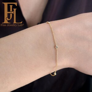 May include: A delicate gold chain bracelet with small round diamonds. The bracelet is on a person's wrist.