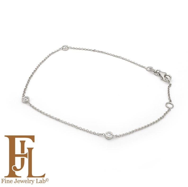 May include: A delicate silver chain bracelet with three small round diamonds.
