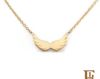May include: A gold-toned necklace featuring a central pendant shaped like a pair of symmetrical angel wings. The pendant is attached to a delicate gold-toned chain. The text Fine Jewelry Lab is visible in the center and bottom right corner.