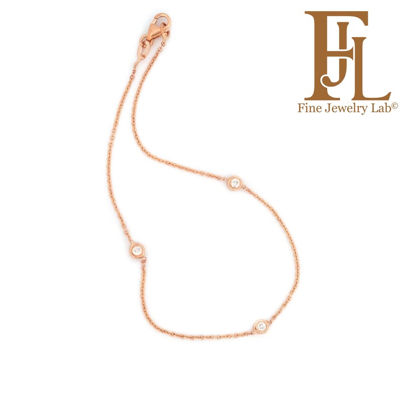 May include: A delicate rose gold chain bracelet with three small round diamonds.