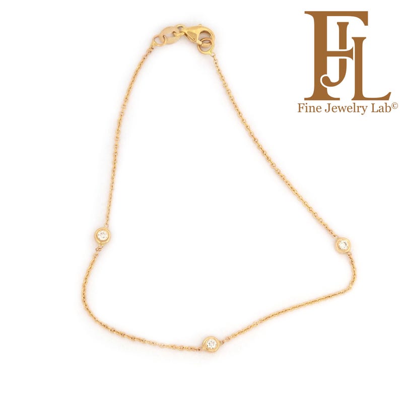 May include: A delicate gold chain bracelet with three small round diamonds.