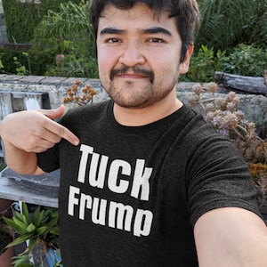 May include: A black t-shirt with the text "Tuck Frump" printed in white.