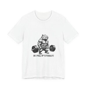May include: White t-shirt featuring a muscular capybara lifting a barbell. The capybara is depicted in a black and white illustration. Below the image is the text "OK I PULL UP (LITERALLY)".