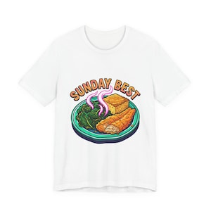Könnte beinhalten: Weißes T-Shirt mit einem farbenfrohen Grafikdesign eines Tellers mit Essen. Auf dem Teller befinden sich Gemüse, Maisbrot und frittierte Speisen, mit dem Schriftzug "SUNDAY BEST" und Dampf, der vom Gericht aufsteigt.