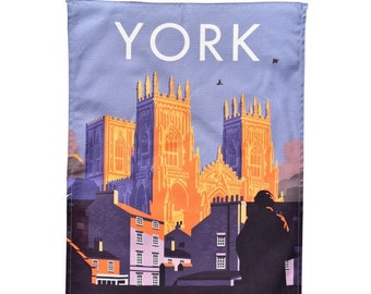 May include: A rectangular tea towel featuring a stylized illustration of York Minster, with the word "YORK" at the top. The image has a purple, orange, and blue color scheme, with the text "YORK MINSTER" at the bottom.