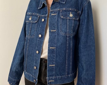 May include: A dark blue denim jacket with silver studs around the collar, pockets, and cuffs.