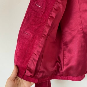 K&ouml;nnte beinhalten: Ein roter Samtblazer mit Satin-Futter. Der Blazer hat einen Knopfverschluss und lange &Auml;rmel.