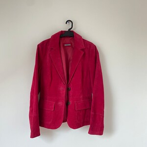 K&ouml;nnte beinhalten: Ein roter Cordblazer mit zwei Kn&ouml;pfen und zwei Taschen.